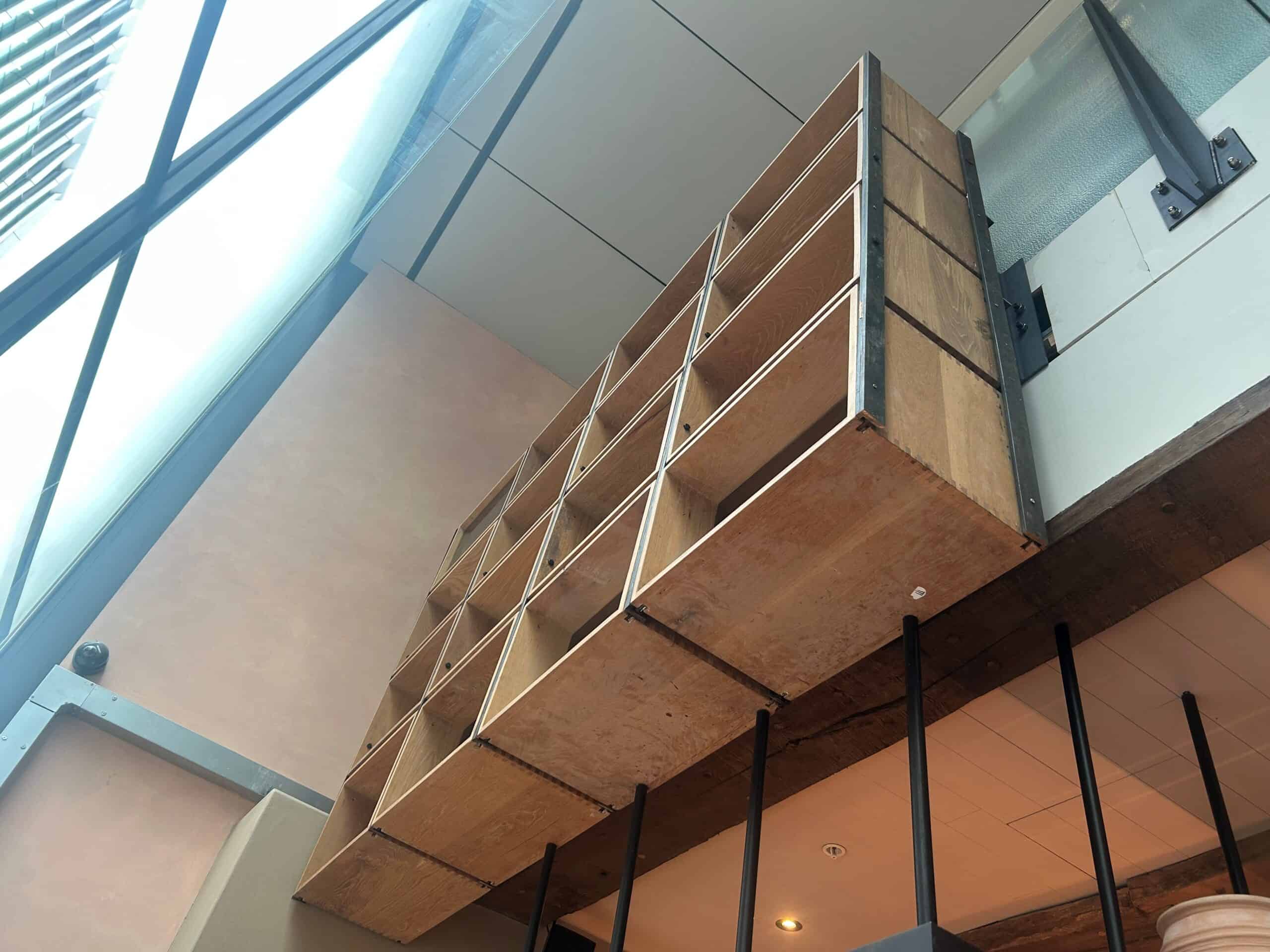 After: timber box shelving suspended above a bar with the steel support fully concealed